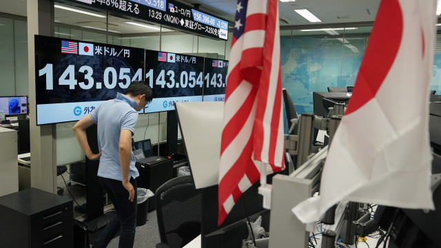 A dealer walks next to monitors showing the foreign exchange rate between the Japanese yen and US dollar in Tokyo, Japan, 05 August 2024
